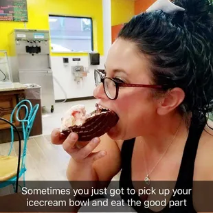 a woman eating a chocolate donut