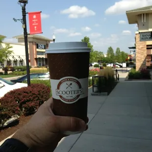 a hand holding a cup of coffee