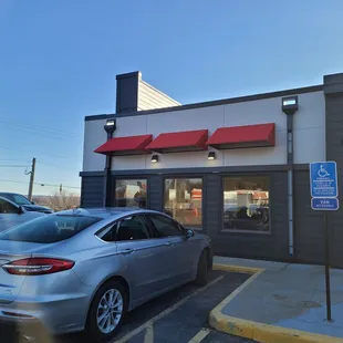 a silver car parked in front of a restaurant