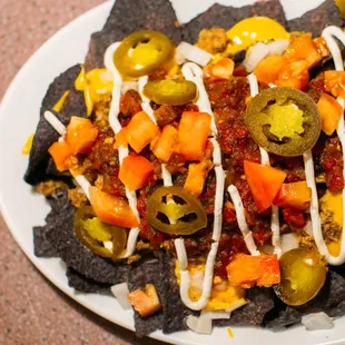 a plate of nachos with cheese sauce