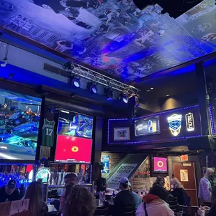 a group of people sitting at tables in a sports bar
