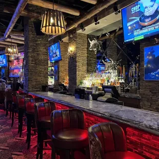 a bar with red chairs