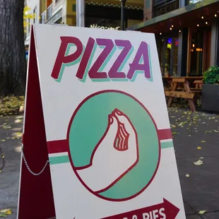 a sign for pizza slices and pies