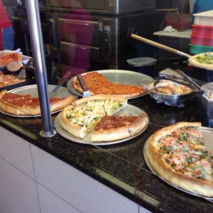 Pizzas ready to go by the slice.