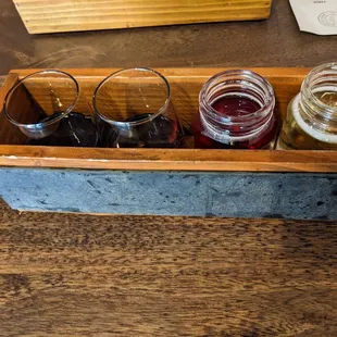 a wooden box with four jars of cid