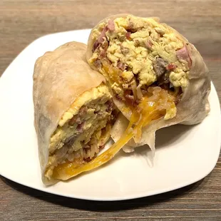 Signature Breakfast Burrito. Egg, cheese, bacon, sausage, ham, and hash browns. Comes with house made salsa.