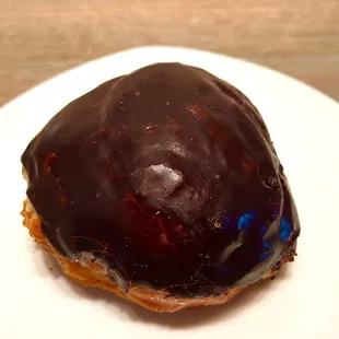 Cream-Filled Chocolate-Iced. Raised donut is infused with vanilla custard cream and topped with a chocolate frosting.