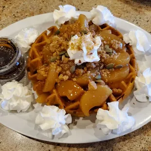 Pumpkin waffle with Dutch apple topping, crumble, pumpkin seeds and whipped cream. Syrup included but not needed!