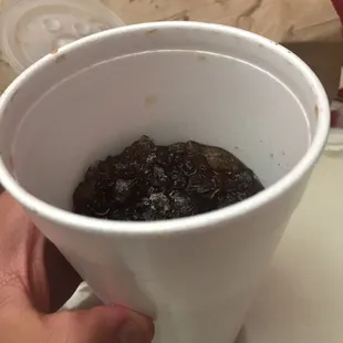 a person holding a cup of hotdogs