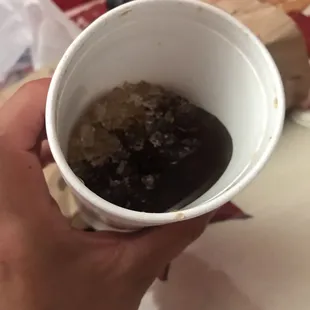 a person holding a cup of hotdogs