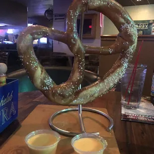 a large pretzel with two dipping sauces
