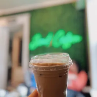 a hand holding a cup of iced coffee