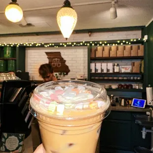 a hand holding a cup of iced coffee