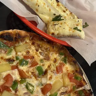 Veggie pizza with cheese bread.
