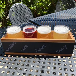 four cups of beer on a tray