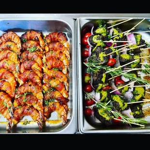 two trays of chicken skewers and vegetables