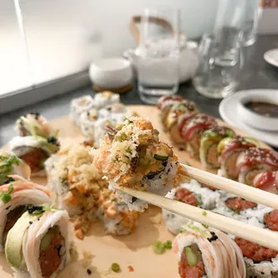 a plate of sushi with chopsticks