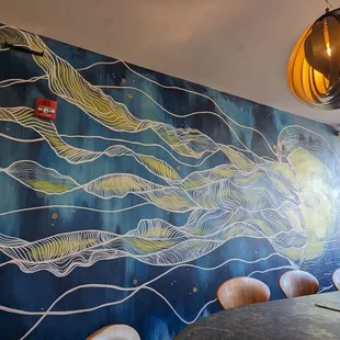 a dining room with a painting on the wall