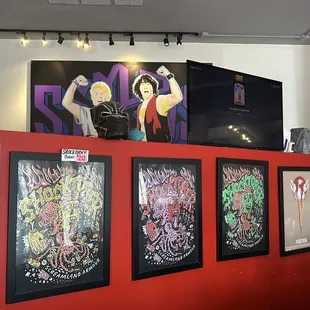 a red wall with posters on it