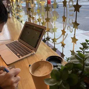 a man writing in front of a laptop