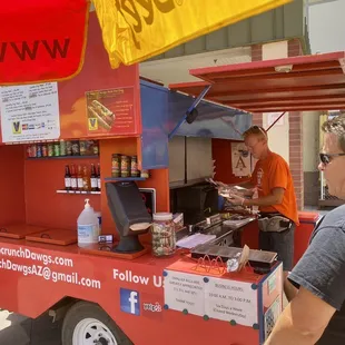 a man ordering food from a food cart