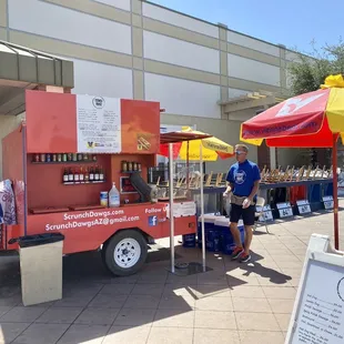 a man standing in front of a food cart