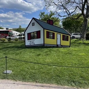a small white house with red shutters