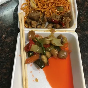 two take out containers with noodles and vegetables