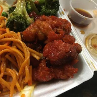 a plate of noodles, meat and broccoli
