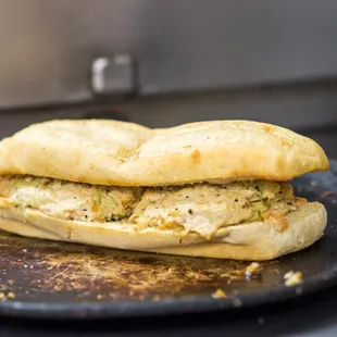 a chicken salad sandwich on a black plate