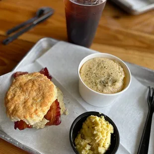 Bacon morning biscuit with a side of scrambled eggs and cheddar chive grits with cold brew.