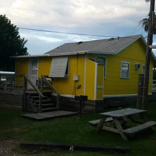 Typical exterior, including picnic table, grill and front porch for each cottage.