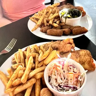 Fried flounder dinners with fries, hush puppies, and coleslaw (front) / collard greens (rear)