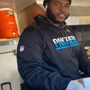 a man in a black hoodie holding a bowl of food