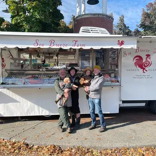 three people standing in front of a food truck