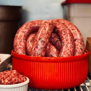 a red bowl filled with sausages