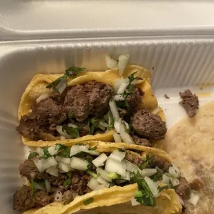 two tacoss in a styrofoam container