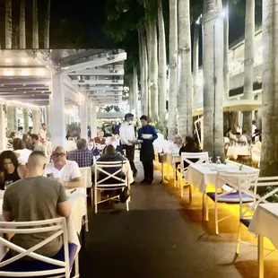 people sitting at tables outside at night