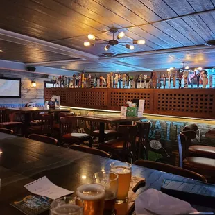 a bar with beer glasses on the bar