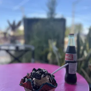 a pink table with a bottle of soda