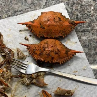 a crab on a napkin with a knife and fork