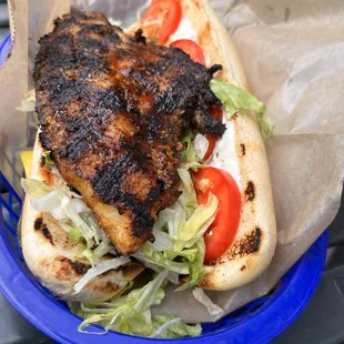 a chicken sandwich with lettuce and tomatoes