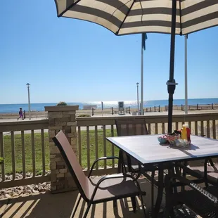 a table and chairs on a patio overlooking the beach