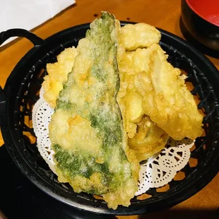 a fried vegetable dish in a black bowl