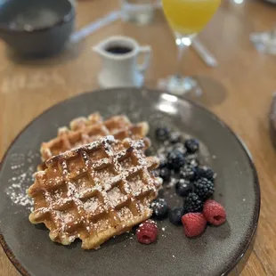 a plate of waffles and berries