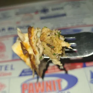 a fork with crab and cheese on it