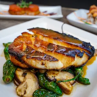 MISO GLAZED CHILEAN SEA BASS 

served on a bed of shishito peppers &amp;
shimeiji mushrooms