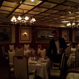 One of the servers preparing a table. Notice the pictures on the wall.