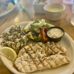 Snapper with a side of lemon cream sauce.