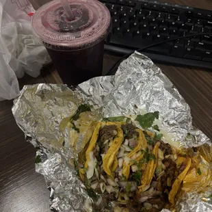 Two Al pastor two asada tacos with Jamaica water.